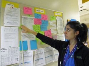 Nureya Khimani, clinical educator, refers to Acute Medicine's infection control focus board. The team uses this board to stay on track and share ideas and patient and family compliments.
