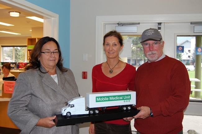 VCH Coastal Co-Sr. Medical Director Dr. Ross Brown presents Pemberton HCC staff with a replica of the Mobile Medical Unit (MMU) as a thank you for the hard work that Pemberton staff put in when the MMU was deployed in their community.