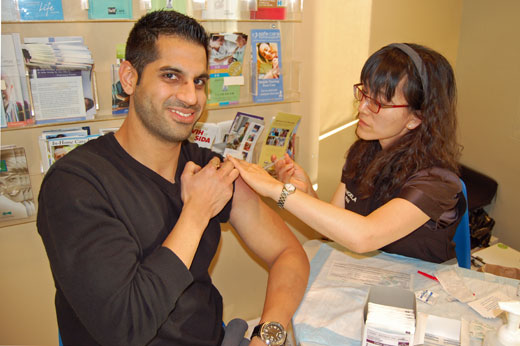 "Fear the flu, not the shot," says PNI Angela Kim, pictured here with   Pramod Johar.