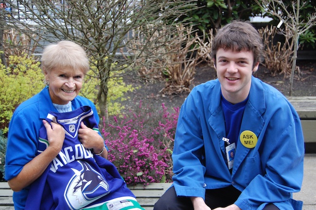 Lions Gate Hospital volunteers Frieda Pahlke (L) and Morgan Haines bring vastly different life experiences to their volunteer roles but share a common motivation: helping make the day of concerned patients and family members a little bit better. Both members of this "dynamic duo" love the variety of their volunteer time as well as the focus on people, some of whom are in distress, which Morgan calls "humbling at times."