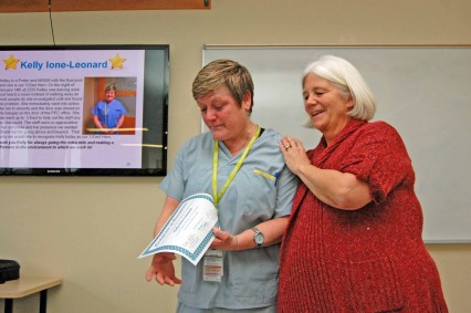 A humbled Kelley-Ione Leonard, a porter at LGH, receives a certificate of staff recognition from Cindy Hartley, Program Manager; Neurosciences/ Pediatrics & Peri-Natal Services, Acute Services.